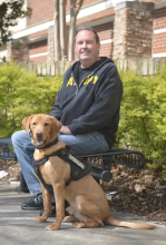 Army veteran John sitting with Savior his service dog