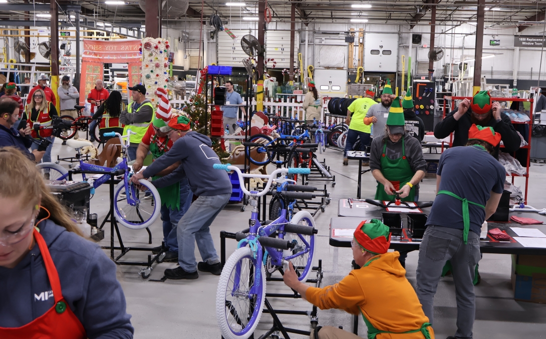MI Windows and Doors team members assemble bicycles to be donated to children in need.